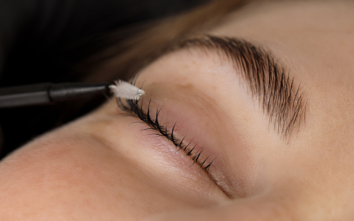 Lash artist using clean tools and applying individual extensions with precision