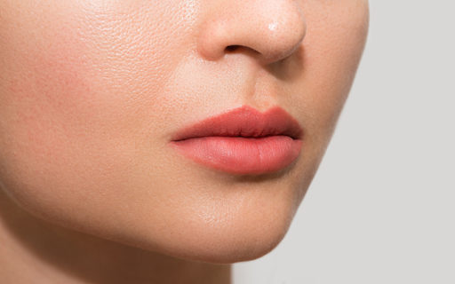A close-up of a woman's lower face, showing off her lips with a soft